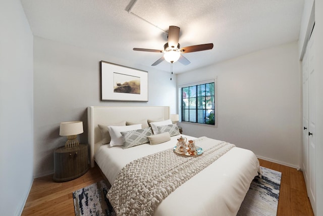 bedroom with hardwood / wood-style floors, a closet, and ceiling fan