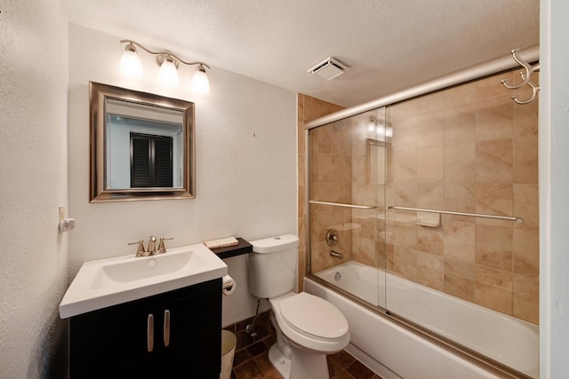 full bathroom with shower / bath combination with glass door, a textured ceiling, vanity, and toilet