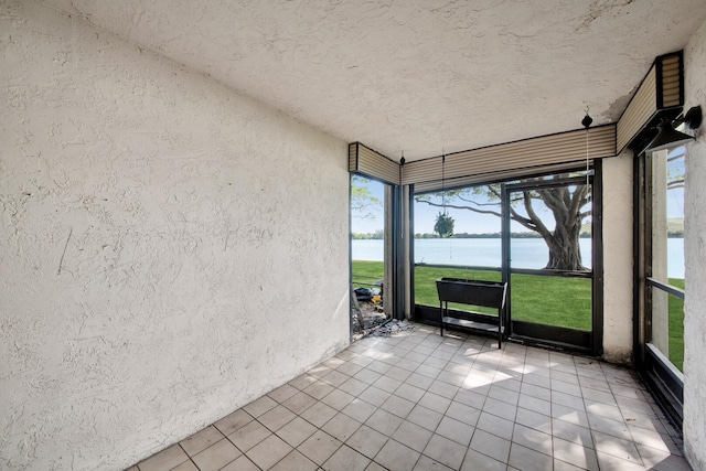 unfurnished sunroom featuring plenty of natural light and a water view