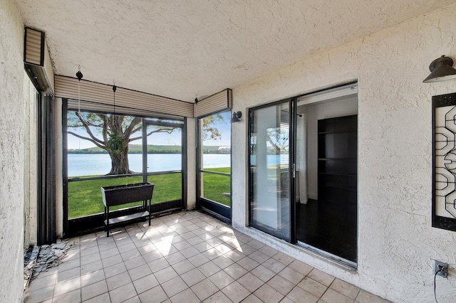 unfurnished sunroom featuring a water view