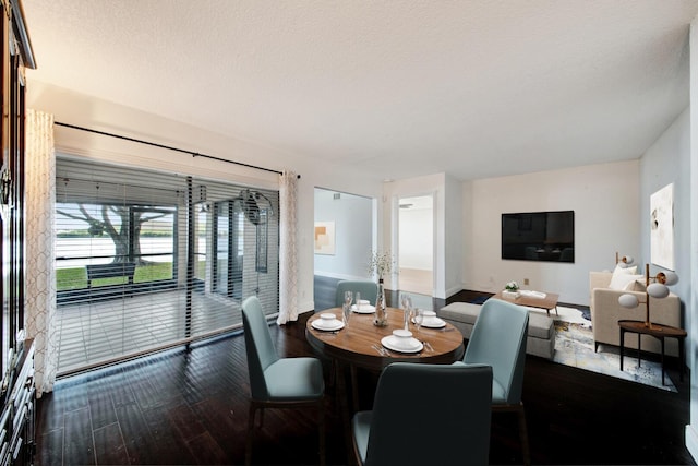 dining space with a textured ceiling and dark hardwood / wood-style flooring