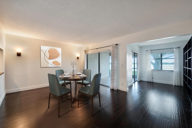 dining space with dark hardwood / wood-style flooring and a textured ceiling