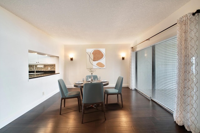 dining space featuring dark hardwood / wood-style flooring and a textured ceiling