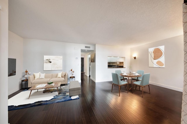 living room with a textured ceiling and dark wood-type flooring