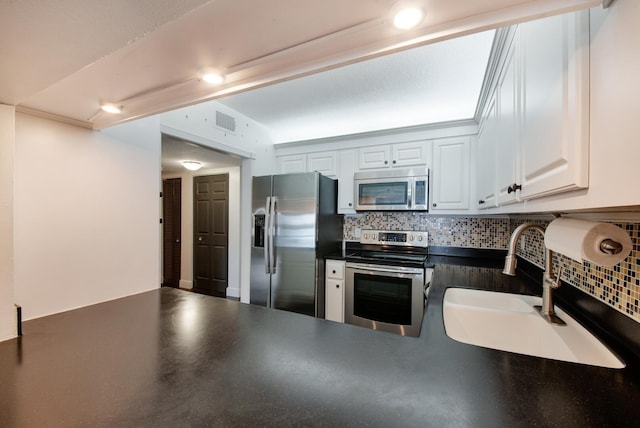 kitchen with backsplash, sink, white cabinets, and stainless steel appliances