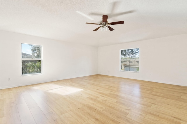 unfurnished room with ceiling fan, a textured ceiling, and light wood-type flooring