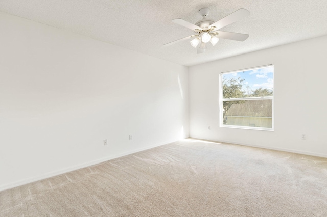 spare room with carpet, a textured ceiling, and ceiling fan