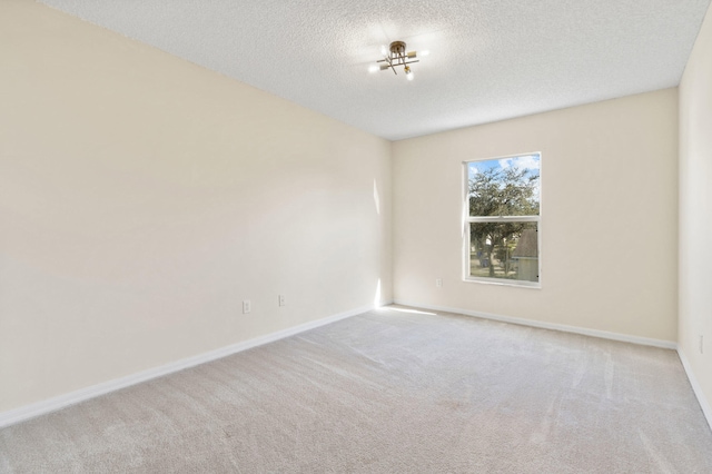 carpeted empty room with a textured ceiling