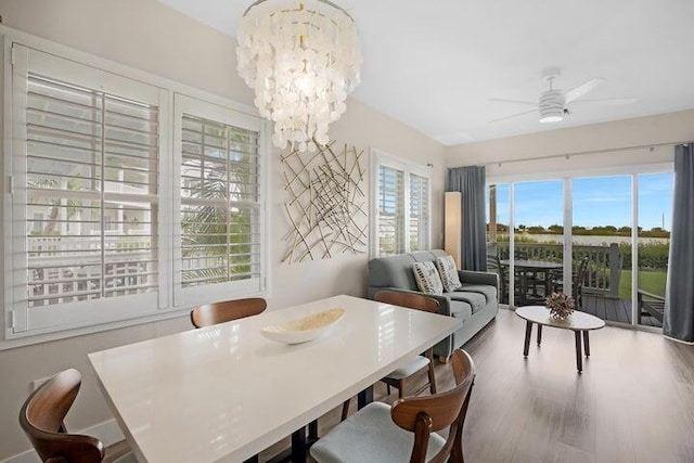 dining space featuring ceiling fan with notable chandelier and hardwood / wood-style floors