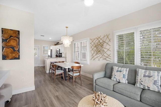 living room featuring a healthy amount of sunlight, a notable chandelier, and hardwood / wood-style flooring