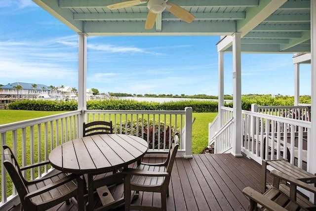 wooden deck featuring ceiling fan and a lawn