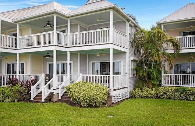 back of property featuring ceiling fan, a yard, and a balcony