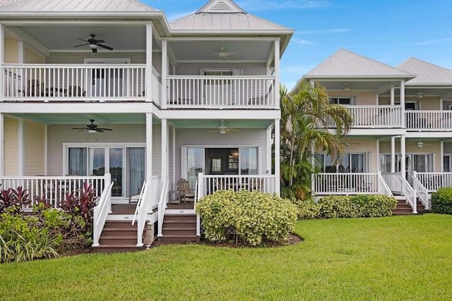 back of property with ceiling fan, a lawn, a balcony, and a porch