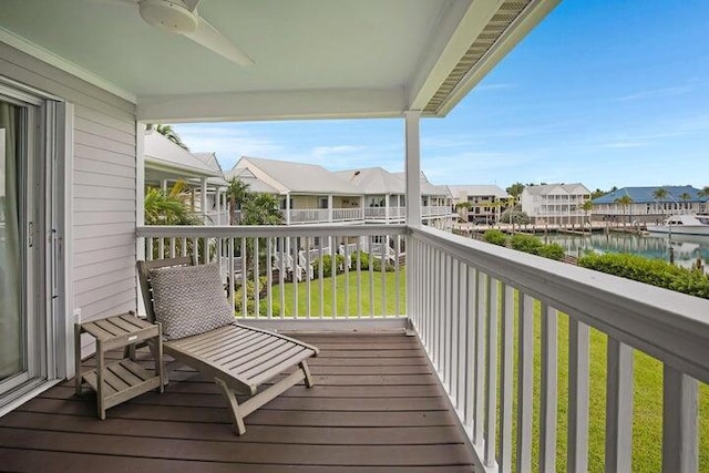 balcony featuring a water view and ceiling fan