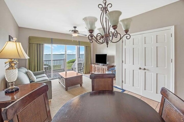 tiled living room featuring ceiling fan with notable chandelier