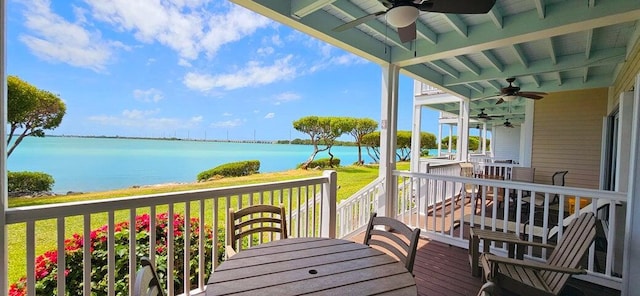 deck with ceiling fan and a water view