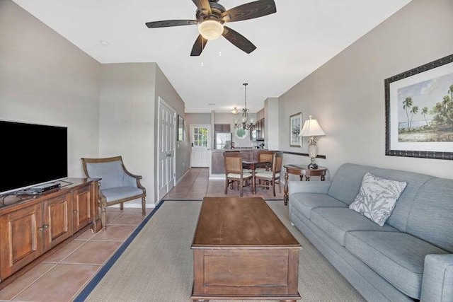 tiled living room featuring ceiling fan with notable chandelier