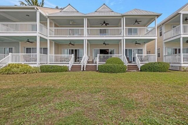 rear view of property featuring a yard and ceiling fan