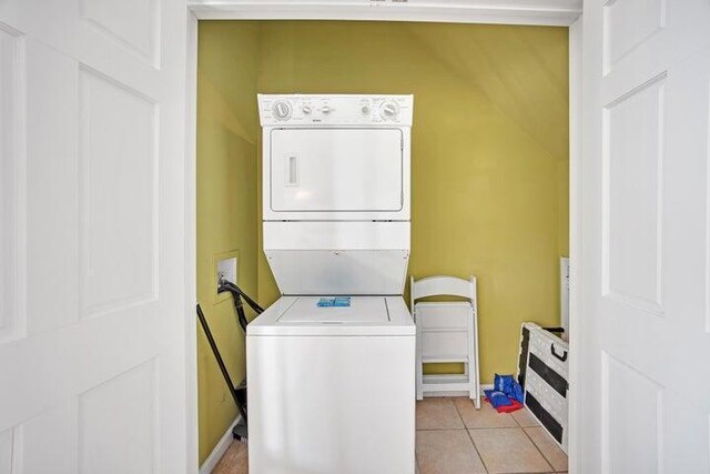 washroom with light tile patterned floors and stacked washer / dryer