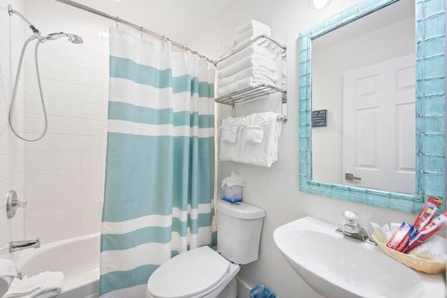 full bathroom featuring sink, toilet, and shower / bath combination with curtain