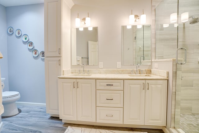 bathroom with wood-type flooring, vanity, toilet, and an enclosed shower