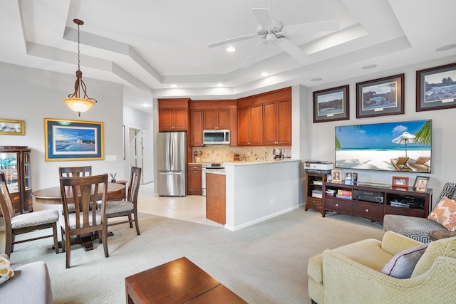 living room with light carpet, a raised ceiling, and ceiling fan