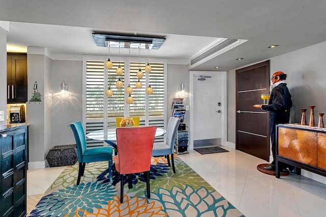 tiled dining space featuring crown molding and a tray ceiling