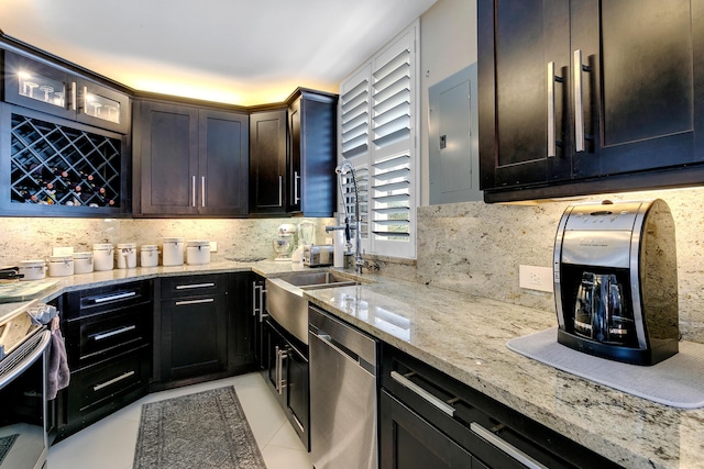 kitchen featuring backsplash, stainless steel dishwasher, light stone counters, light tile patterned floors, and electric panel