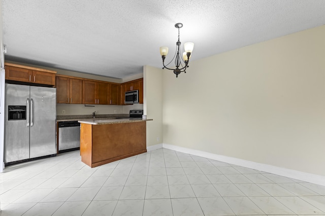 kitchen featuring a textured ceiling, decorative light fixtures, kitchen peninsula, stainless steel appliances, and a chandelier