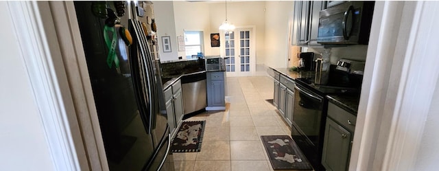 kitchen with light tile patterned floors, black appliances, decorative light fixtures, and an inviting chandelier