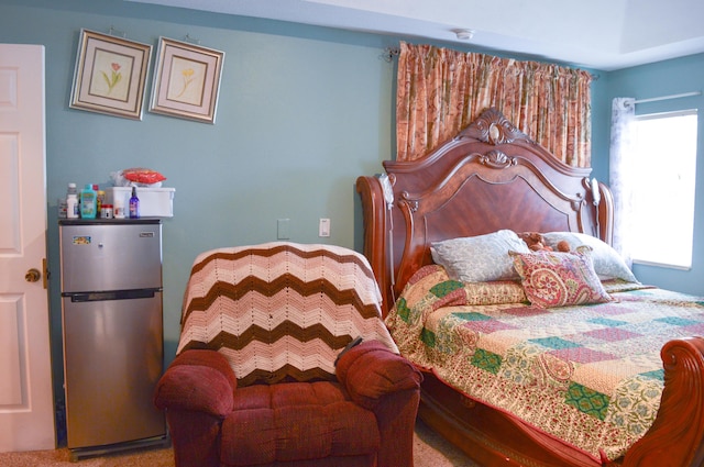 bedroom featuring stainless steel fridge and carpet floors