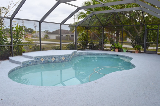 view of pool with glass enclosure