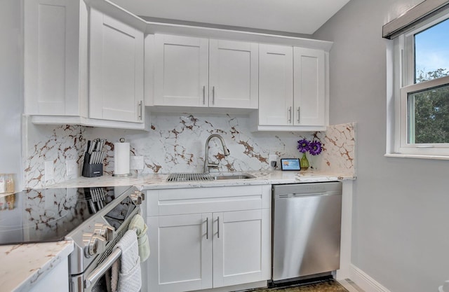 kitchen featuring white cabinets, stainless steel appliances, tasteful backsplash, and sink