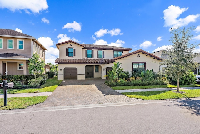 mediterranean / spanish-style home with a garage and a front yard