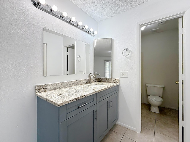 bathroom featuring a textured ceiling, visible vents, tile patterned flooring, vanity, and toilet