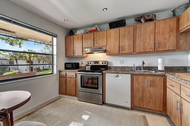 kitchen featuring dishwasher, light tile patterned flooring, stainless steel range with electric stovetop, and sink