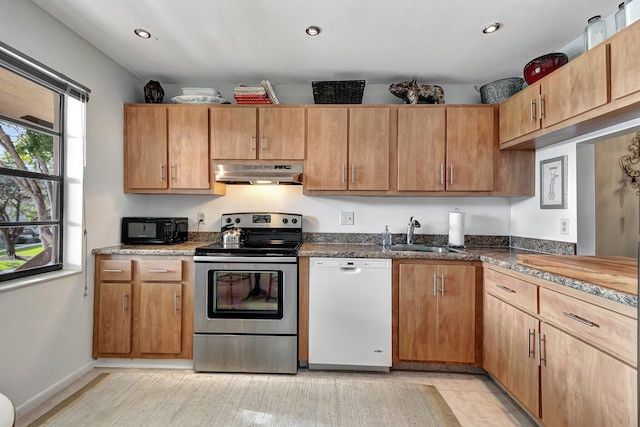 kitchen with dark stone countertops, dishwasher, stainless steel electric range, and sink