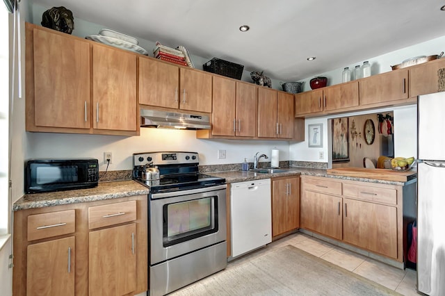 kitchen with light tile patterned flooring, white appliances, and sink