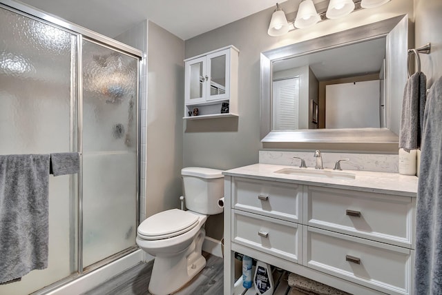 bathroom featuring vanity, hardwood / wood-style flooring, toilet, and walk in shower