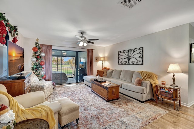 living room with ceiling fan and light wood-type flooring