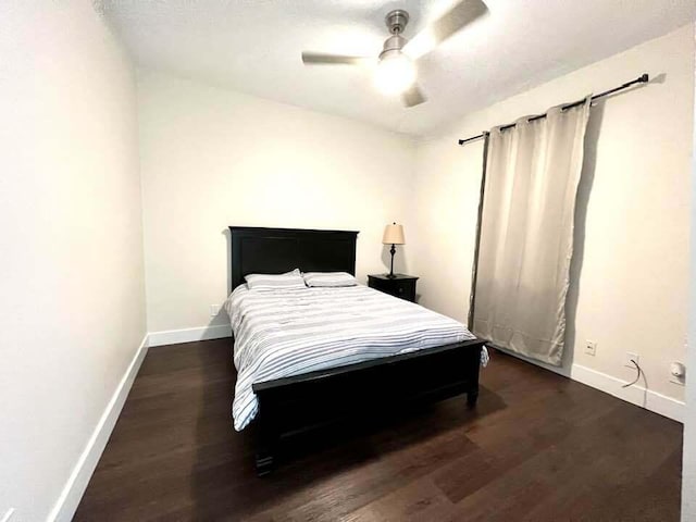 bedroom with ceiling fan and dark wood-type flooring