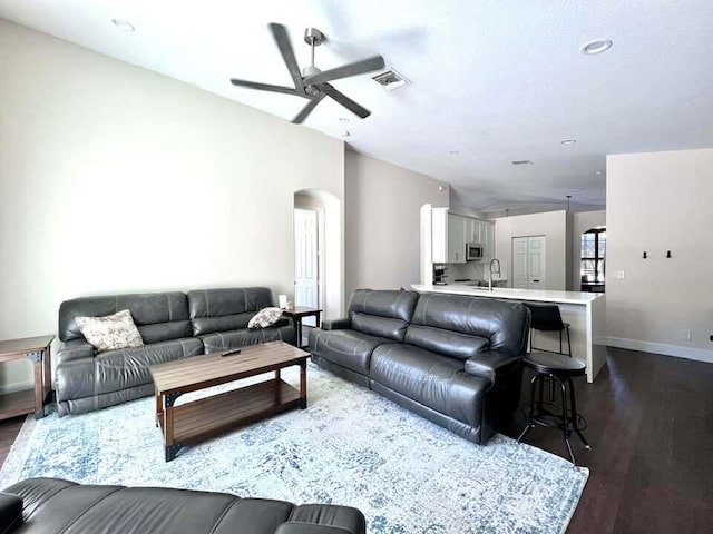 living room featuring dark hardwood / wood-style floors, ceiling fan, and sink