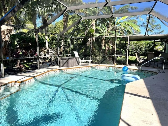 view of pool featuring glass enclosure and a patio