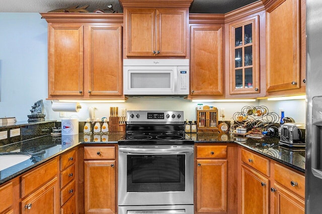 kitchen featuring dark stone countertops, a textured ceiling, and appliances with stainless steel finishes