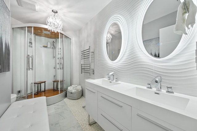 bathroom with vanity, an inviting chandelier, and an enclosed shower