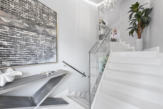 staircase featuring an inviting chandelier