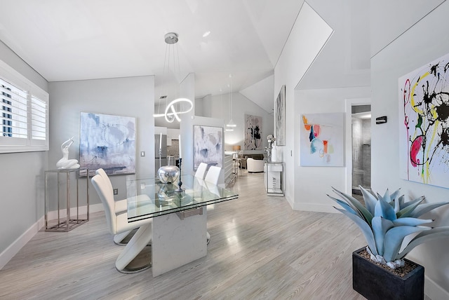 dining space with light hardwood / wood-style flooring and lofted ceiling