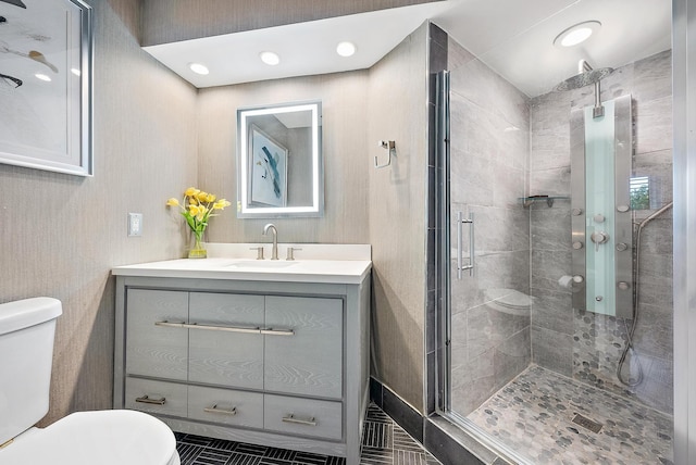 bathroom with vanity, toilet, and a shower with door