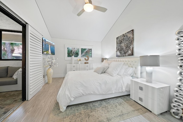 bedroom with ceiling fan, light hardwood / wood-style floors, and vaulted ceiling