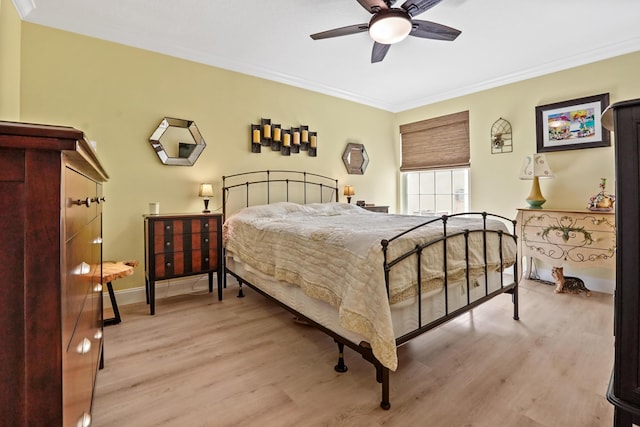 bedroom featuring light hardwood / wood-style flooring, ceiling fan, and ornamental molding